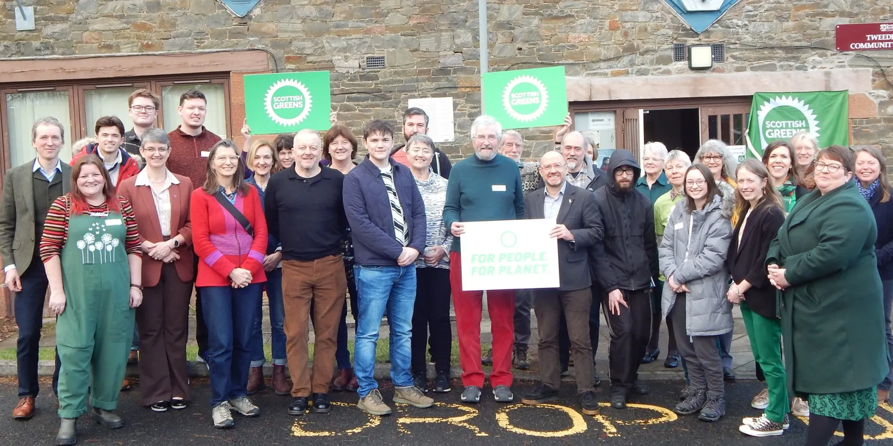 Scottish Borders Greens campaigners and supporters holding Scottish Greens placards.